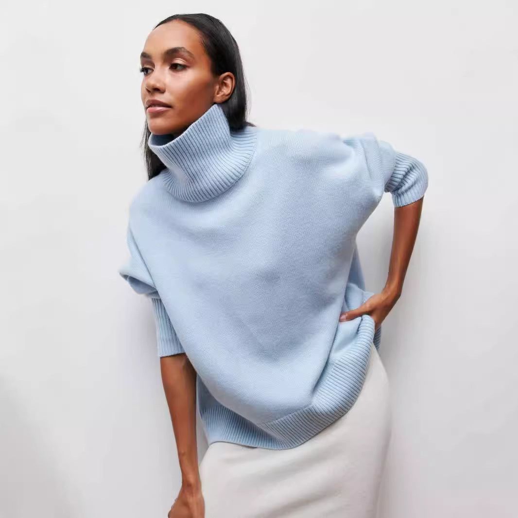 Woman wearing a light blue turtleneck sweater against a plain background