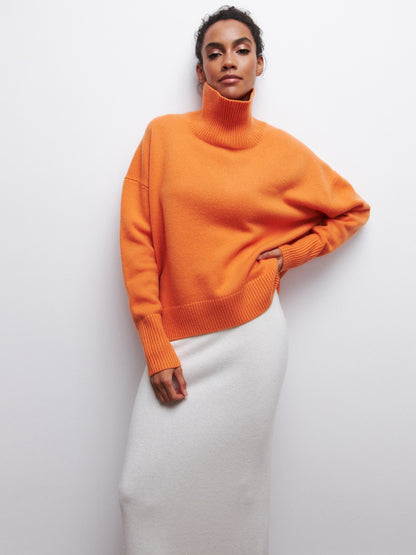 Person wearing an orange sweater against a white background