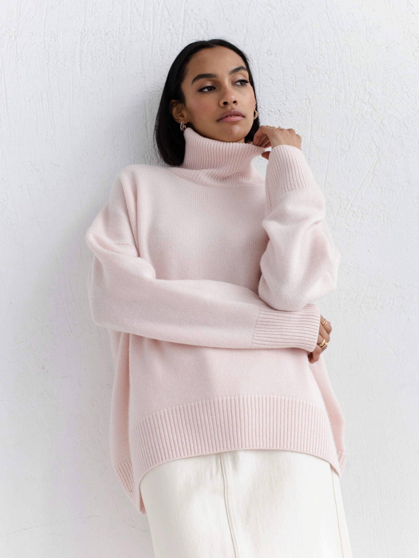 Woman wearing a light pink sweater against a white background