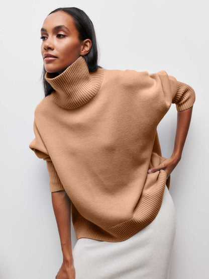 Woman wearing a beige turtleneck sweater against a white background